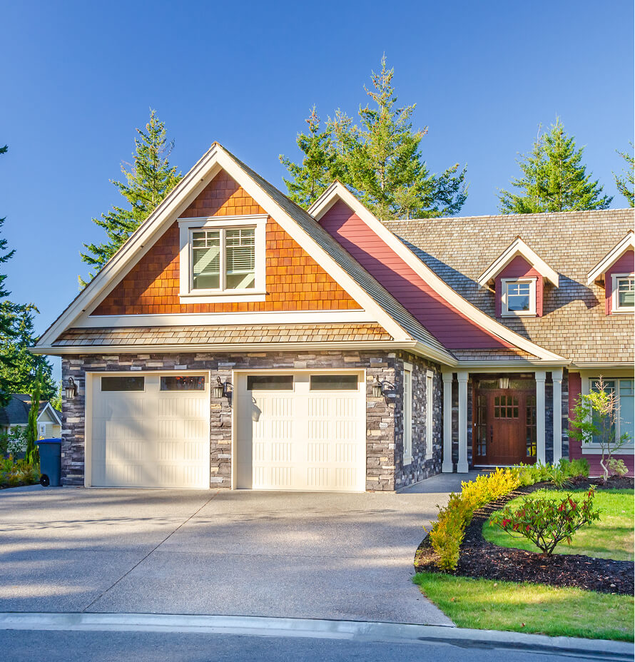 A residential house featuring a combination of stone and wood siding with a two-car garage.
