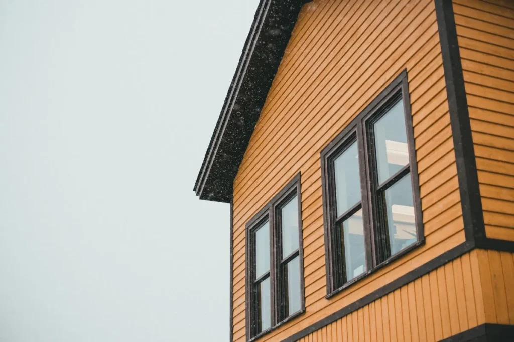 Best siding for Calgary climate with wood lap siding on a home during light snowfall