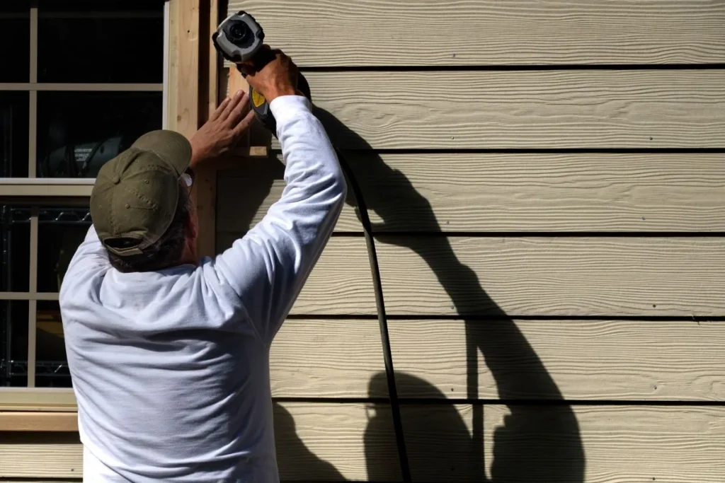 Contractor installing fiber cement lap siding for a hardie board siding cost calgary project